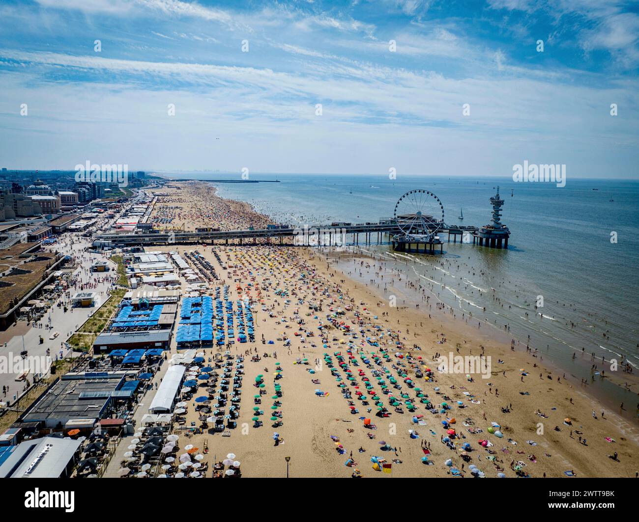 SCHEVINGEN - folle sulla spiaggia di Scheveningen durante i giorni tropicali, molte persone si godono il bel sole sulla spiaggia. Foto Stock