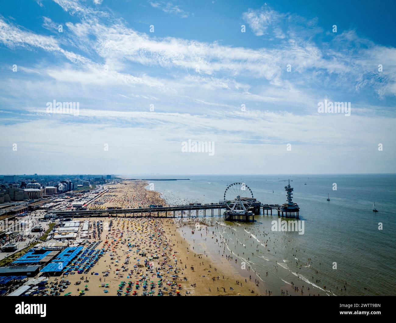 SCHEVINGEN - folle sulla spiaggia di Scheveningen durante i giorni tropicali, molte persone si godono il bel sole sulla spiaggia. Foto Stock