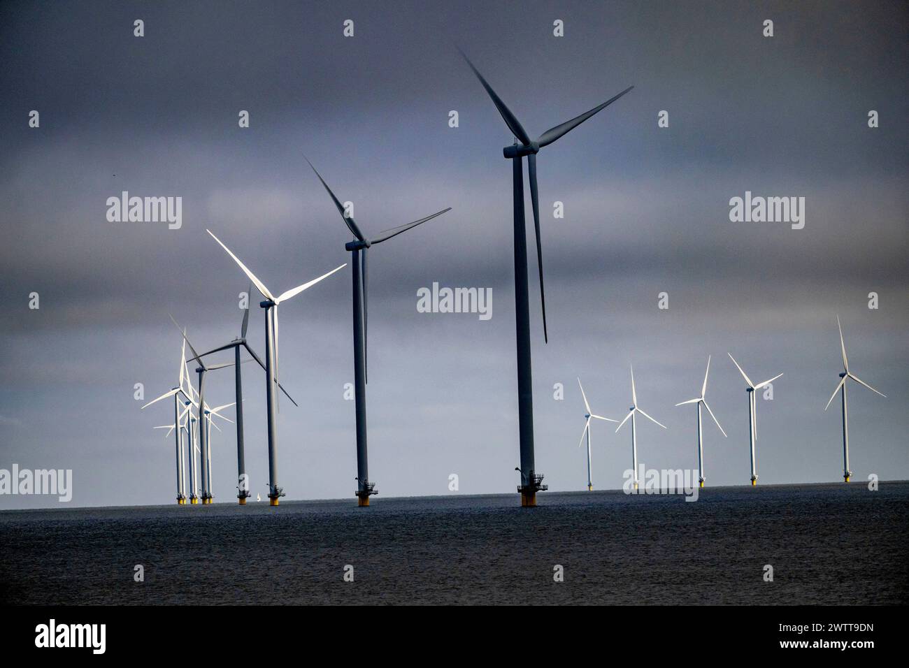 Turbine eoliche alte in mare aperto sotto un cielo lunare. Foto Stock