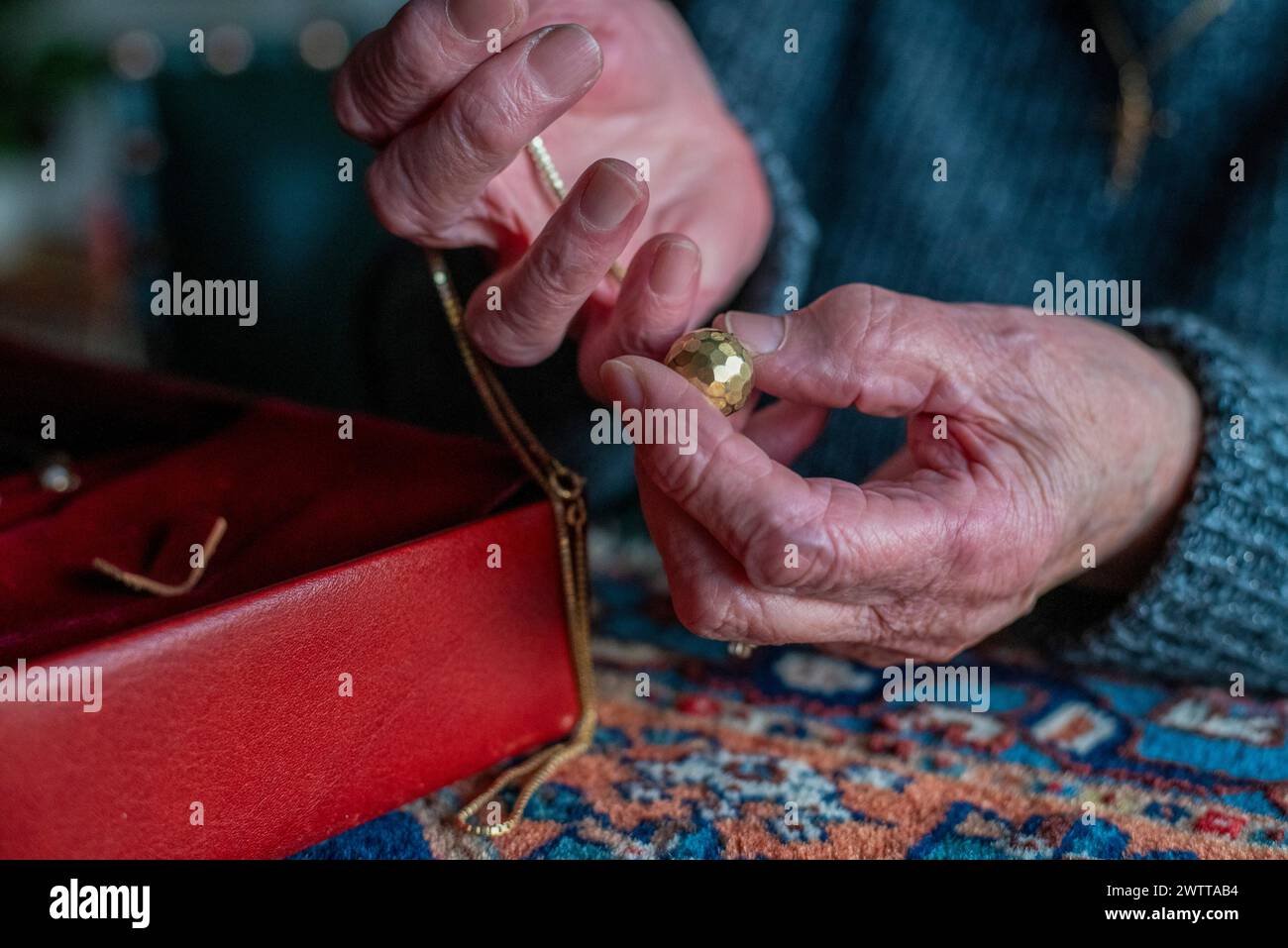 Primo piano delle mani di una persona esaminando con perizia un pezzo di gioiello. Foto Stock
