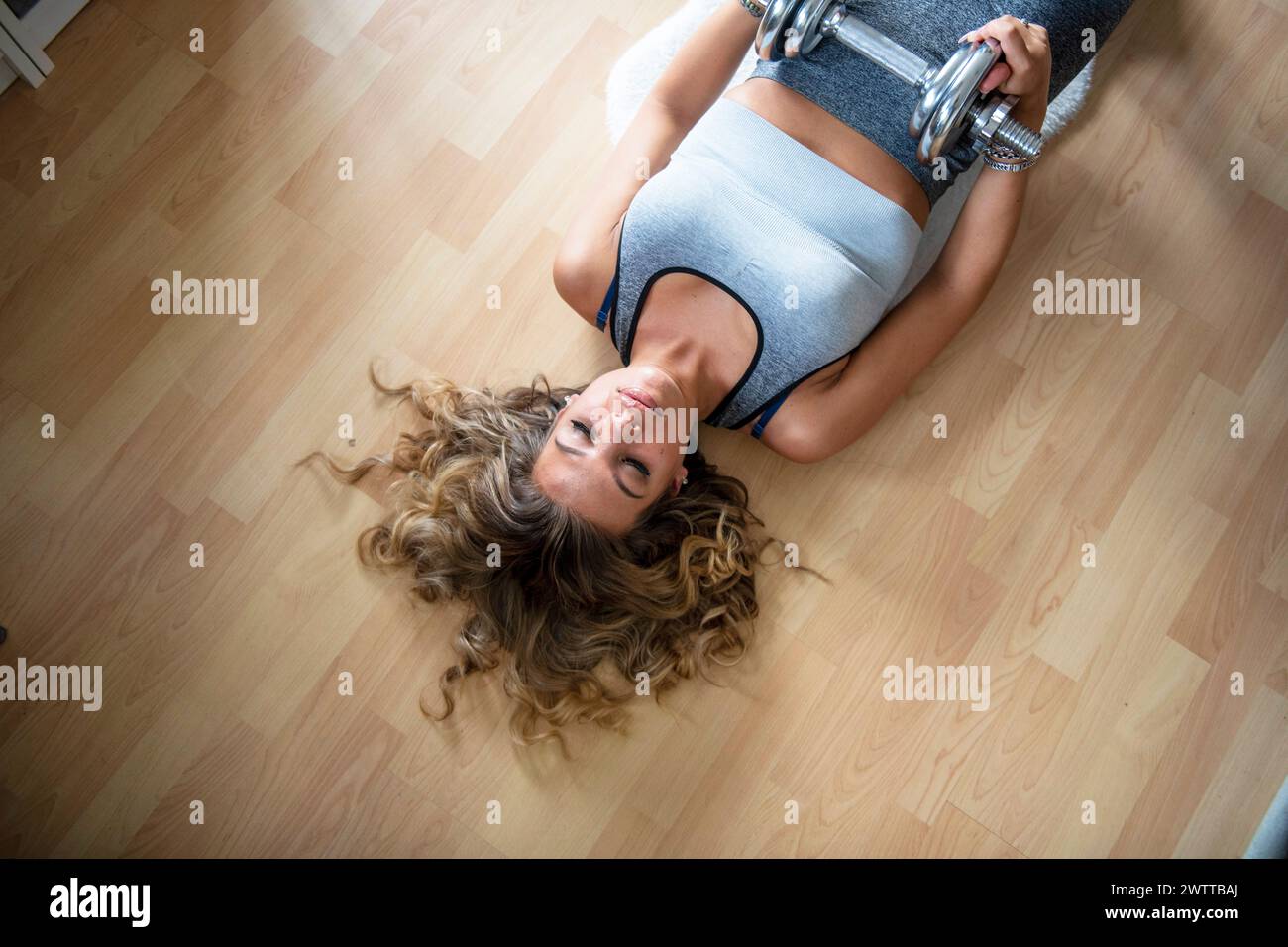 Giovane donna sdraiata sul pavimento con un'espressione serena. Foto Stock