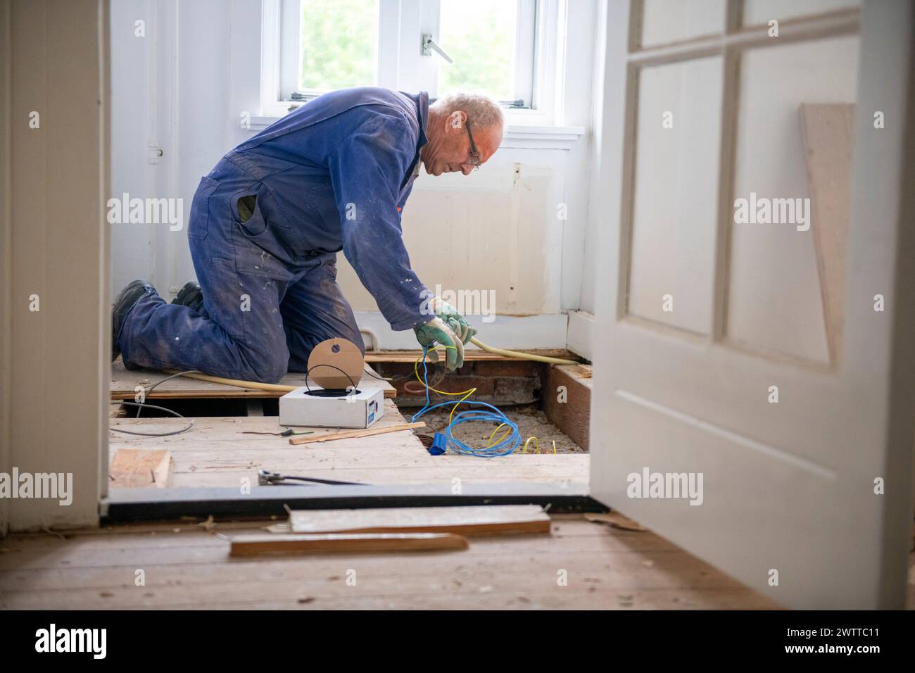 Lavoratore anziano coinvolto in un progetto di ristrutturazione della casa. Foto Stock