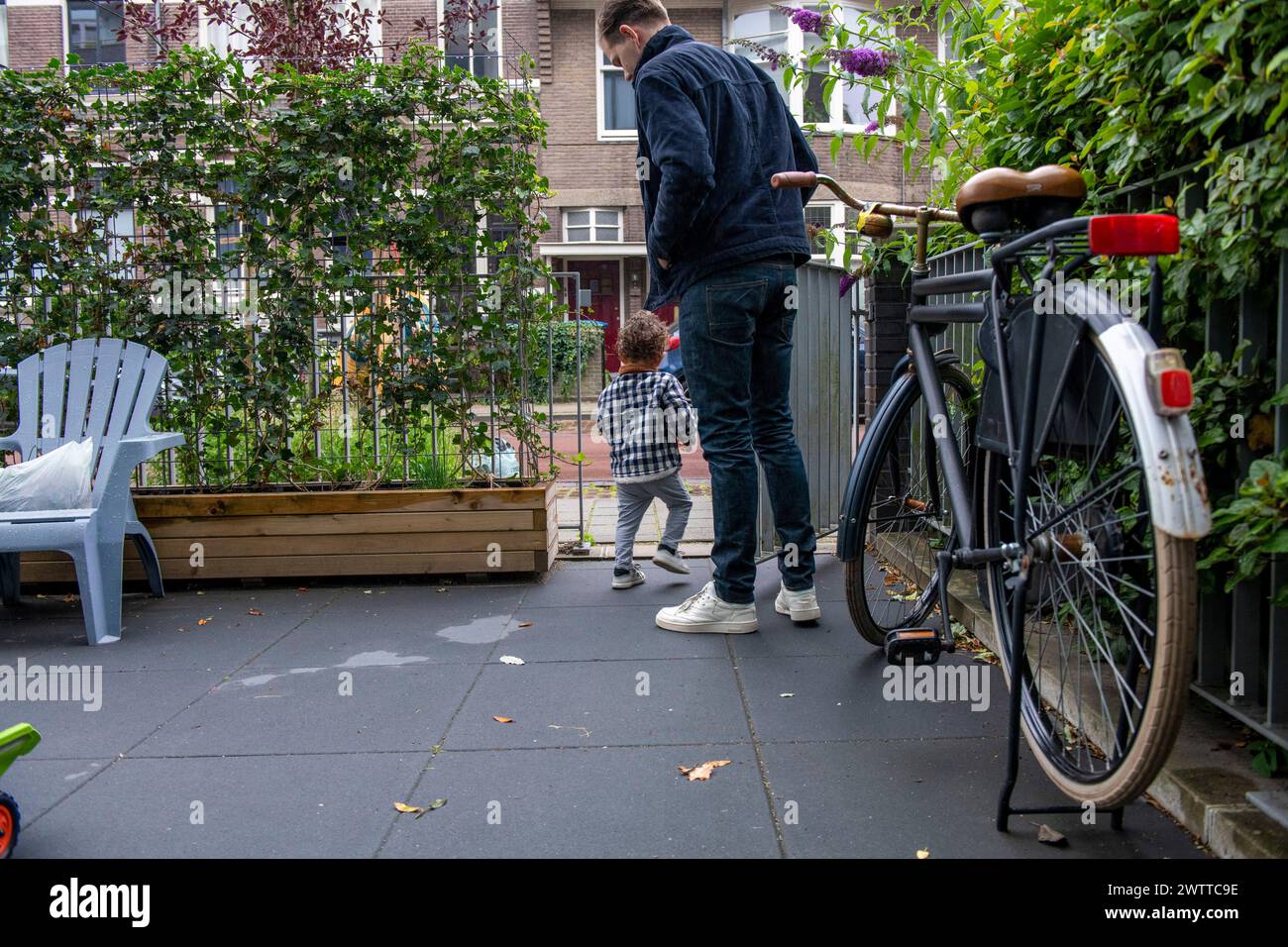 Un momento di connessione quando un bambino guarda un adulto in un accogliente patio urbano. Foto Stock