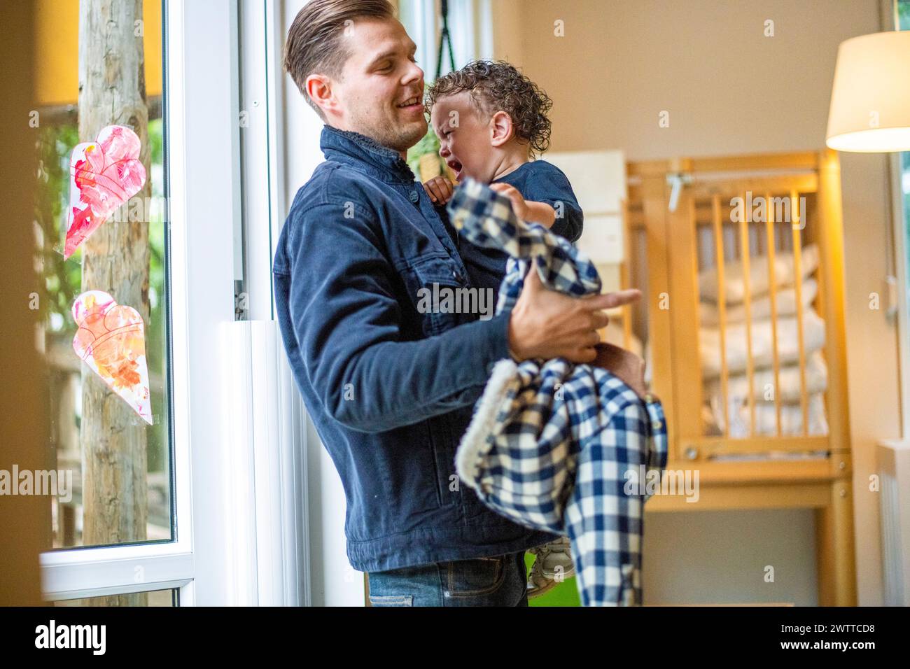 Padre che condivide un momento di gioia con il suo bambino a casa Foto Stock