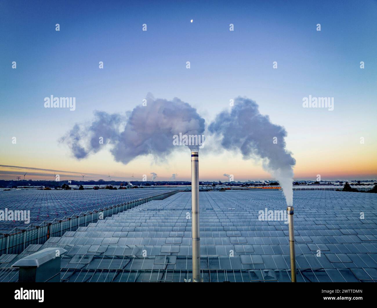 Gli Smokestacks punteggiano un tranquillo skyline crepuscolare Foto Stock