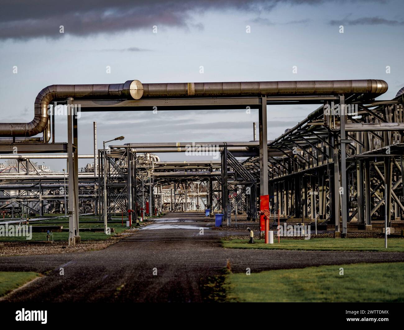 Labirinto complesso di tubi industriali contro un cielo ammuffito Foto Stock