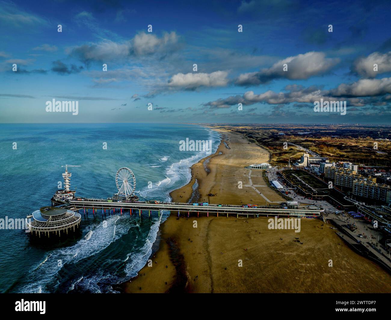 Vista aerea di una vivace città costiera con un vivace molo e una ruota panoramica Foto Stock