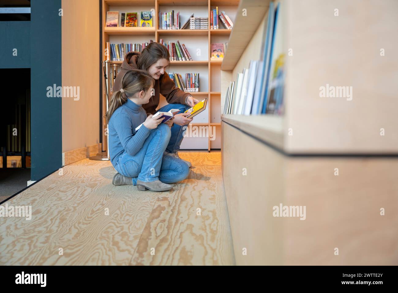 Un intimo momento di lettura tra genitori e bambini a casa Foto Stock