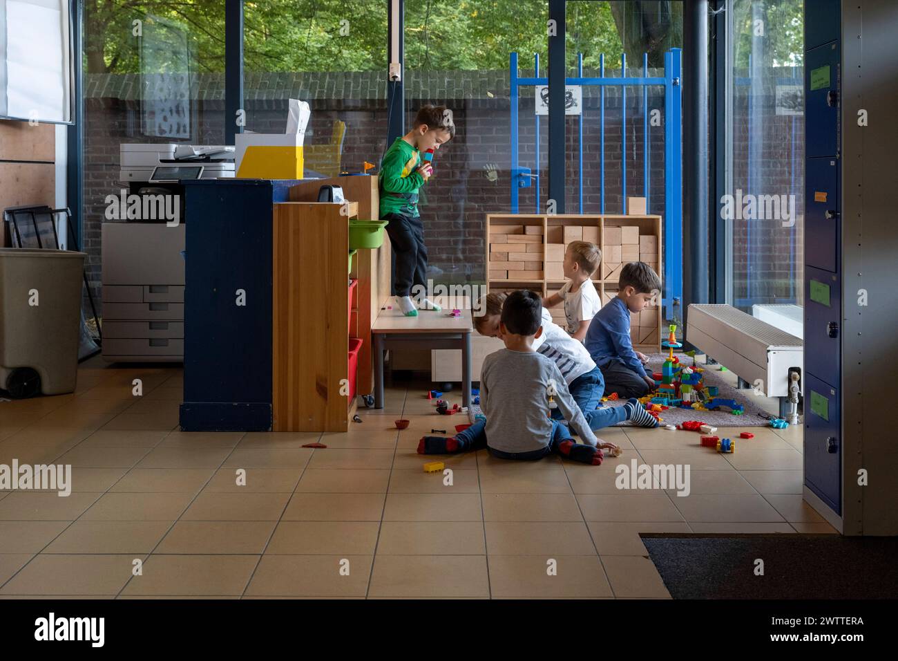 Bambini impegnati in attività ludiche in una colorata sala giochi interna. Foto Stock