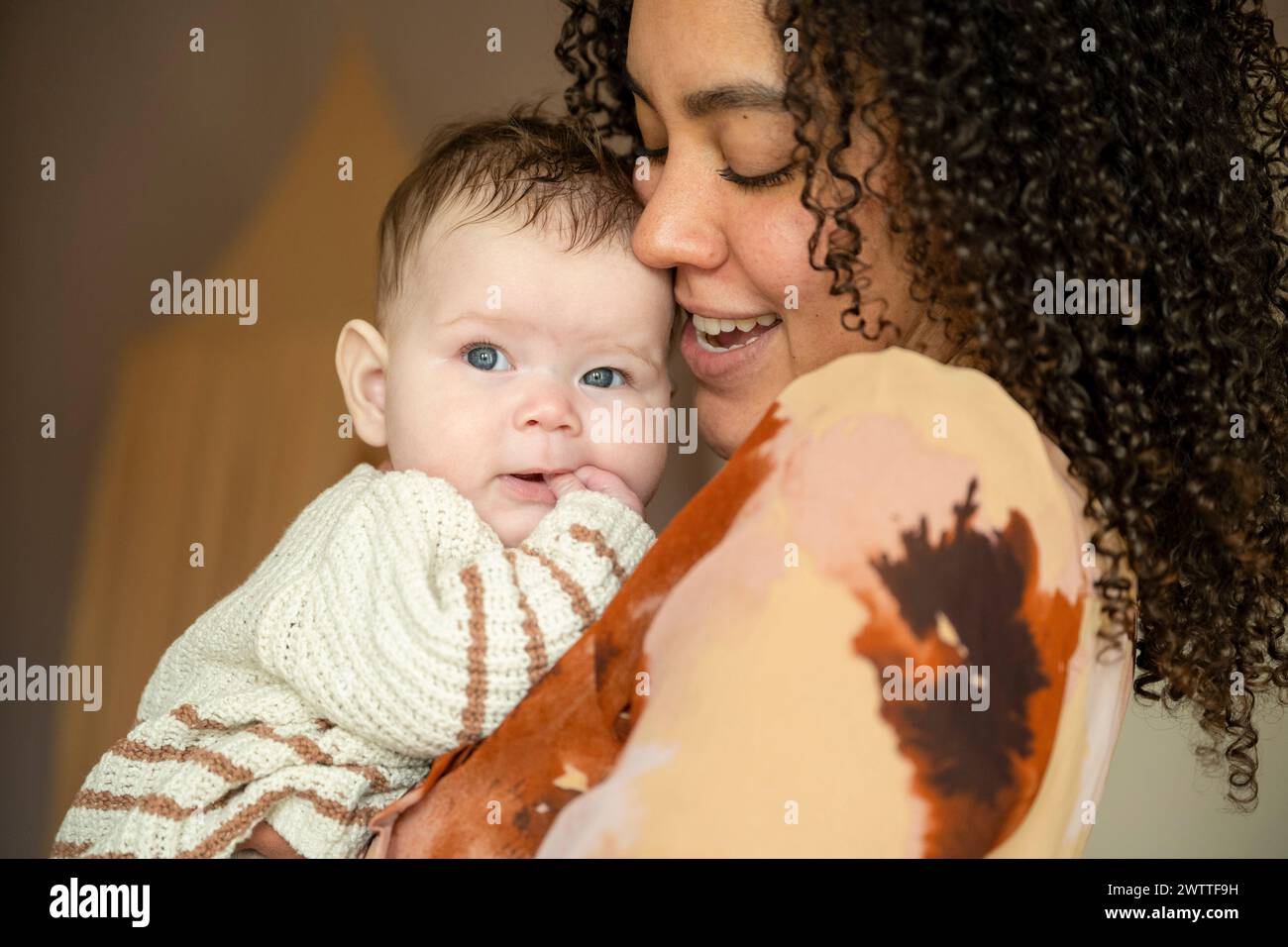 Un momento tenero come una madre coccola il suo bambino con affettuosa gioia. Foto Stock