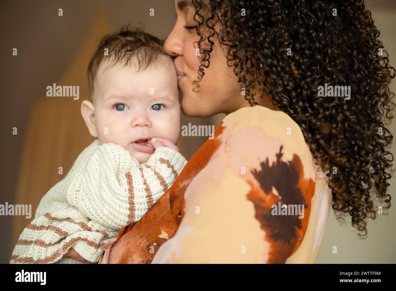 Un momento tenero mentre una madre coccola il suo bambino vicino. Foto Stock