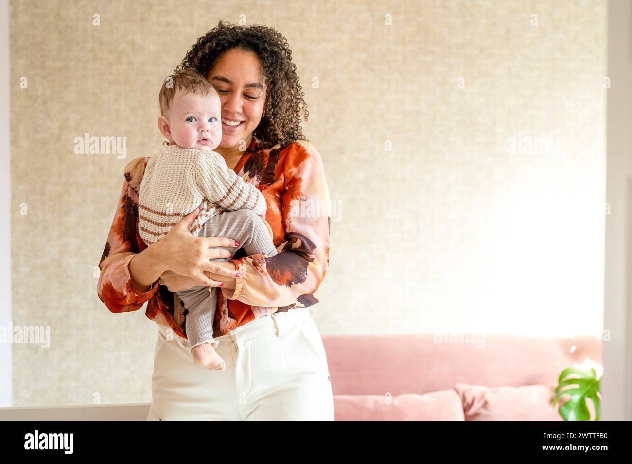 Un caldo abbraccio tra una madre e il suo bambino a casa Foto Stock