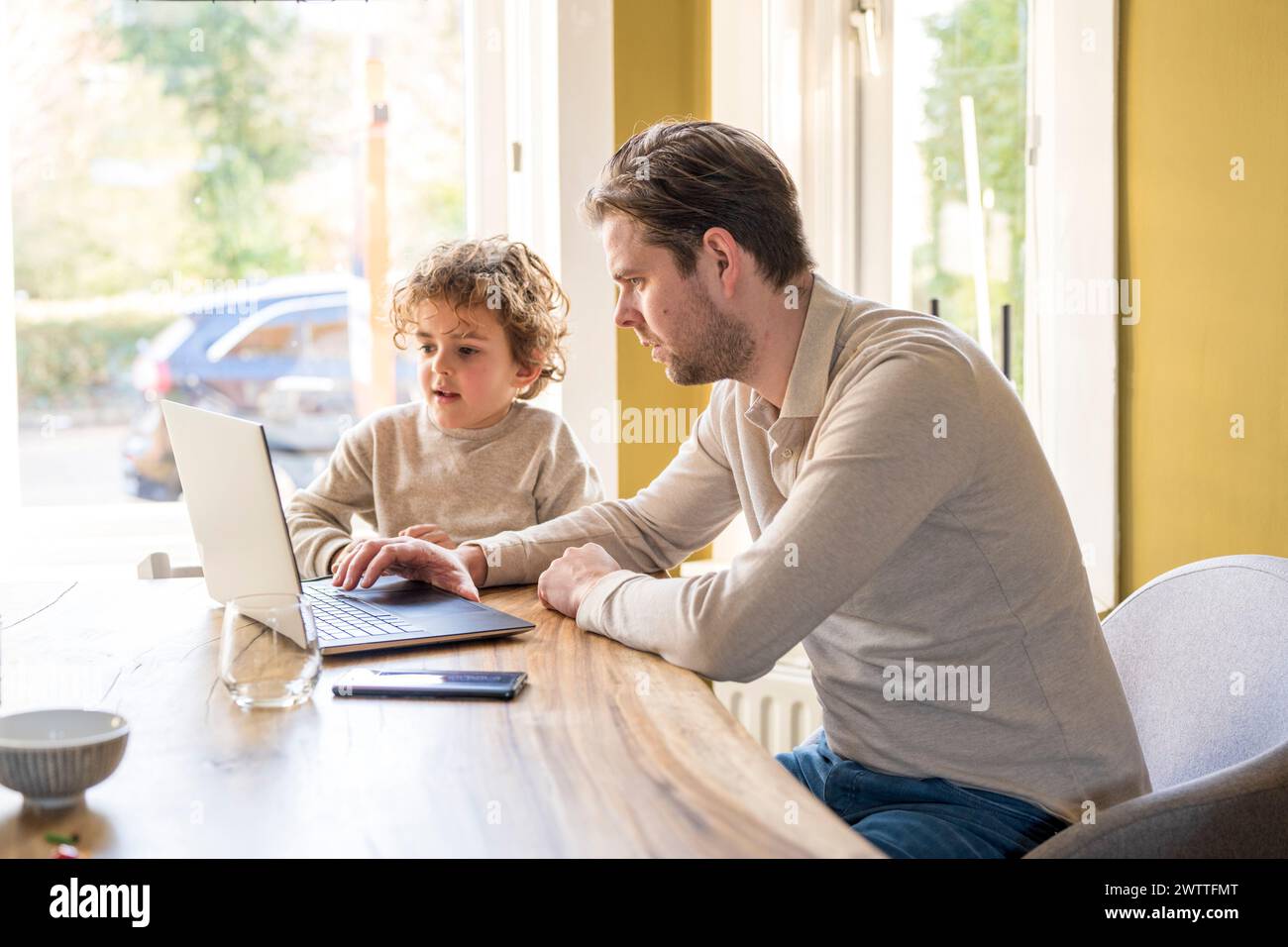 Padre e figlio esplorano il mondo digitale insieme. Foto Stock