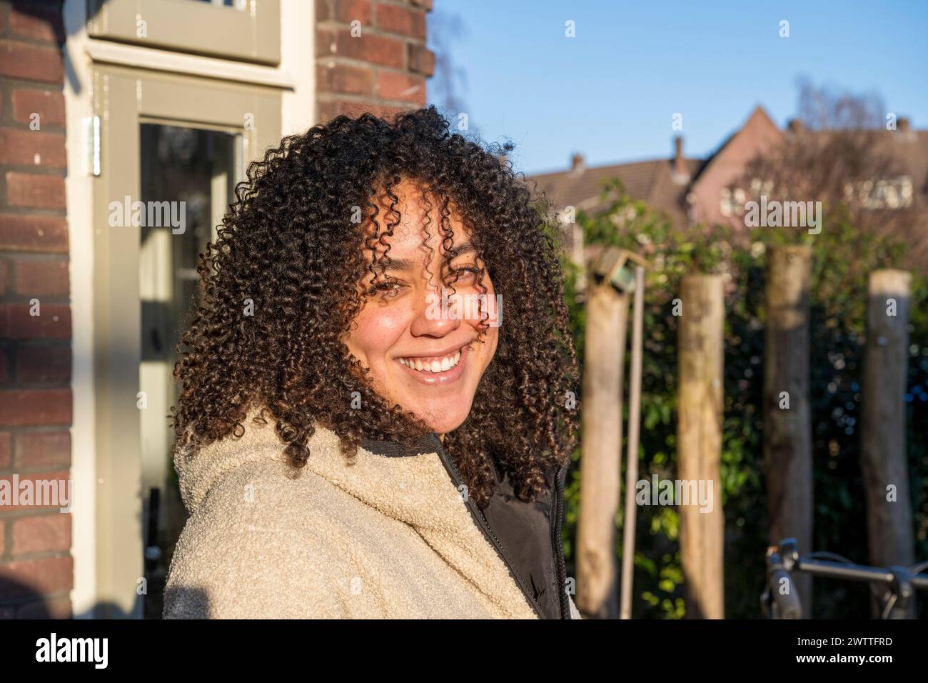 Donna sorridente che si gode una giornata di sole nei sobborghi Foto Stock