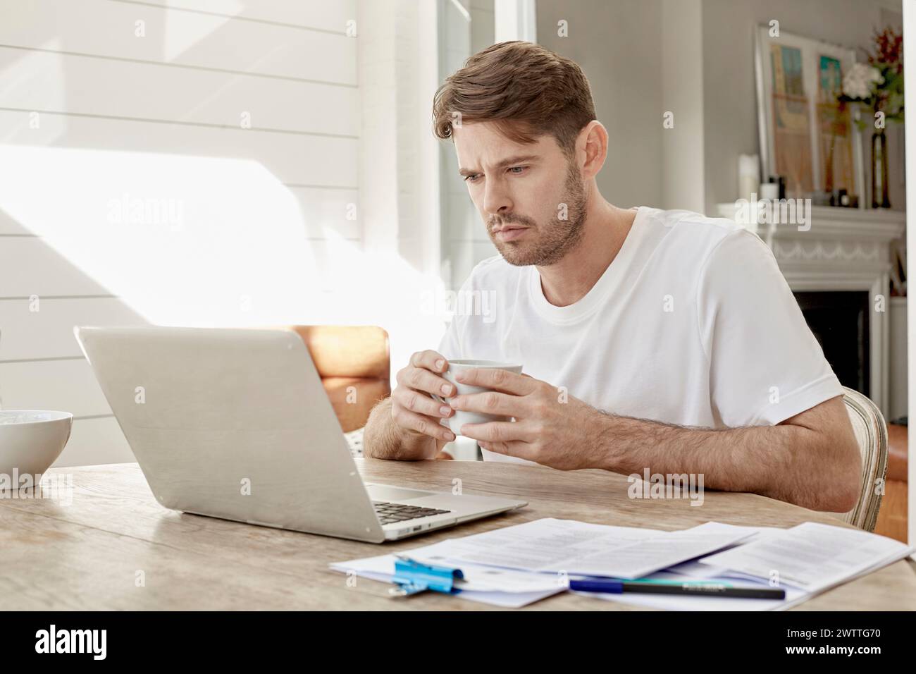 Uomo che lavora al computer portatile con caffè Foto Stock