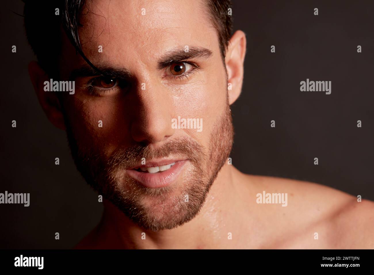 Uomo con capelli bagnati e sguardo intenso Foto Stock