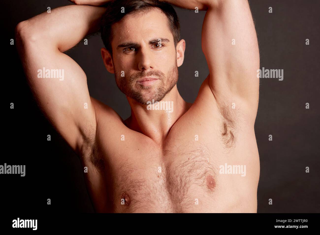 Uomo in posa con le braccia sollevate dietro la testa Foto Stock