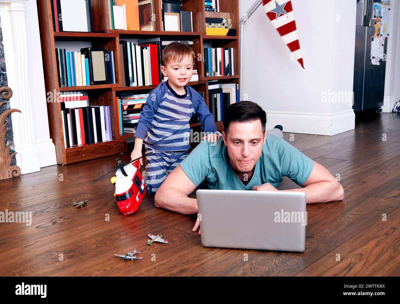 Bambino e adulto con un computer portatile sul pavimento Foto Stock