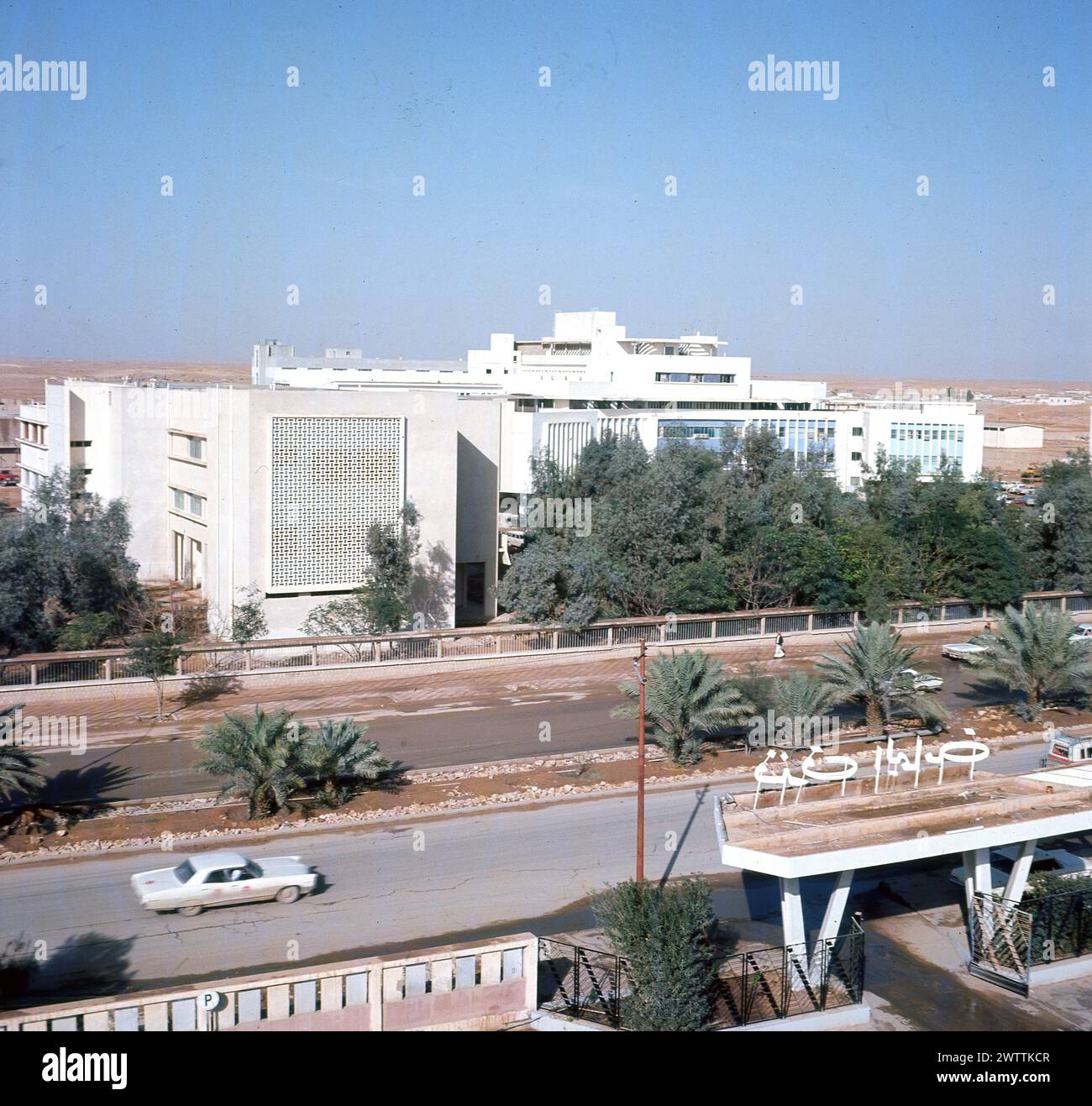 1960, storica vista esterna dell'edificio del Ministero degli interni a Riyadh, Arabia Saudita. Il ministero è stato istituito nel 1926 dal re Abd al-Aziz come dipartimento governativo per supervisionare la sicurezza nazionale, in un momento di disordini politici e conflitti tribali, con l'obiettivo di raggiungere la sicurezza e la stabilità per i suoi cittadini. Nel 1953 re Sa'ud trasferì tutti i distretti governativi dalla Mecca a Riad e furono costruiti nuovi edifici ministeriali, insieme a una nuova periferia per ospitare il personale e così la piccola città deserta fu trasformata in una moderna capitale, su una scala e a una velocità finora inosservata. Foto Stock