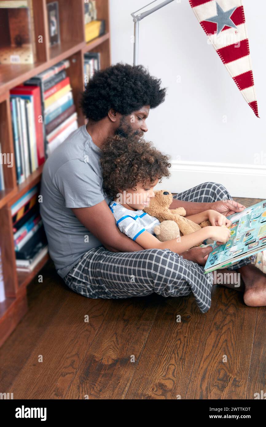 Padre e figlio leggono un libro insieme Foto Stock