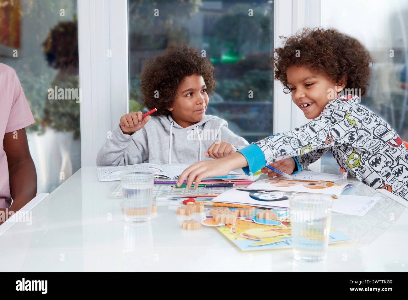Due bambini possono divertirsi con le attività colorate a un tavolo. Foto Stock