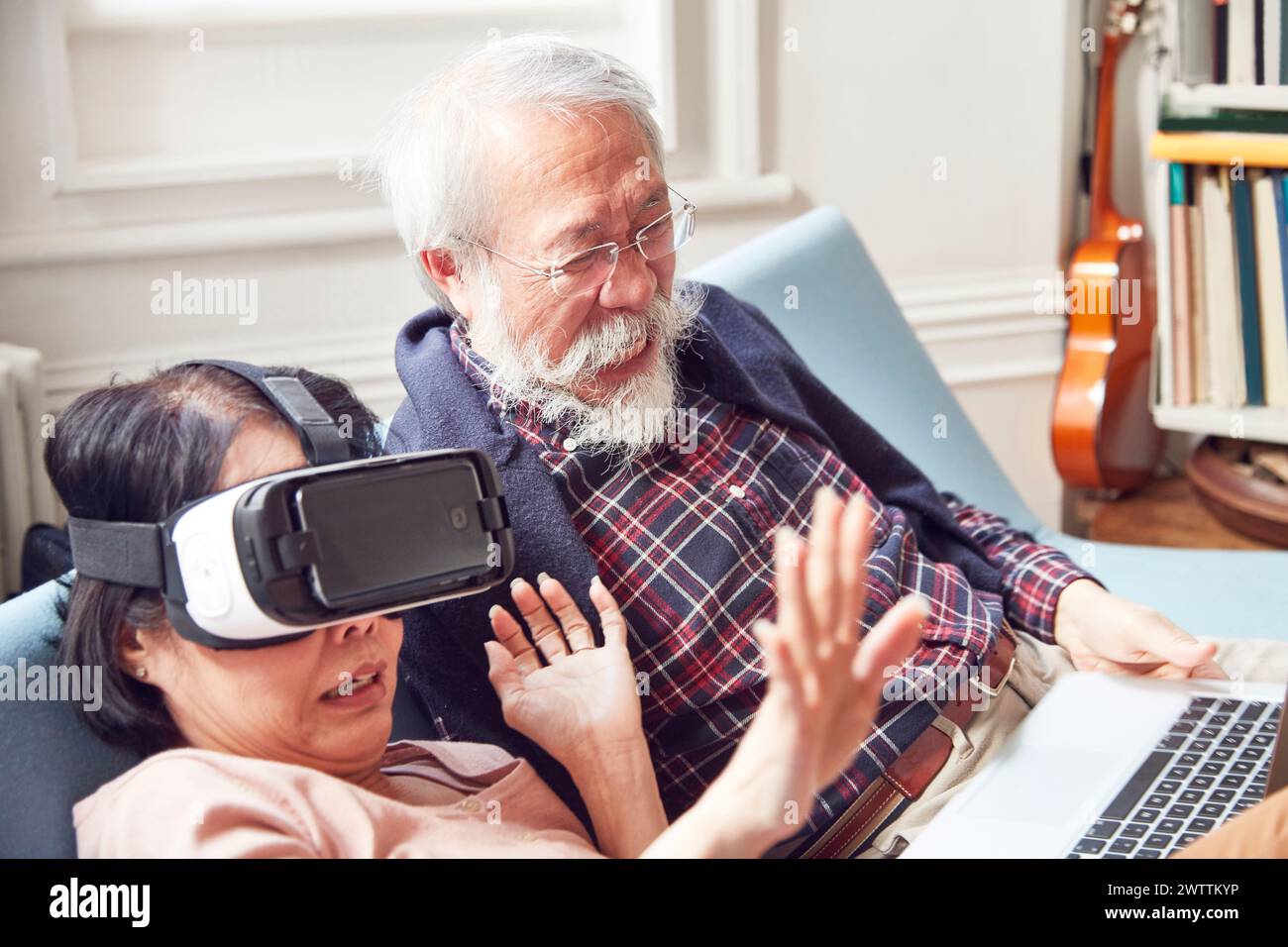 Coppia di anziani con donna che usa il visore VR Foto Stock
