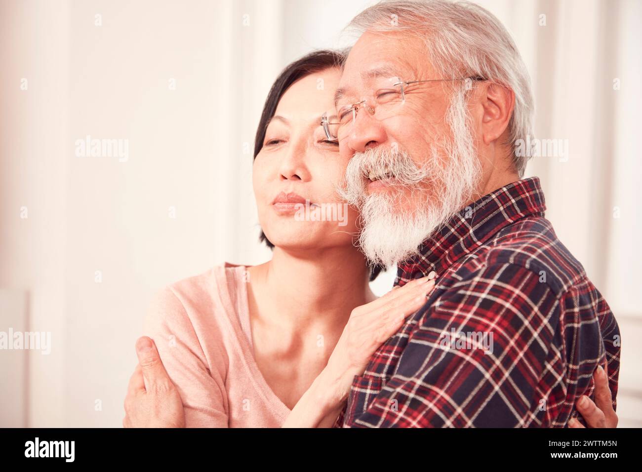 Uomo anziano abbracciato da una donna. Foto Stock