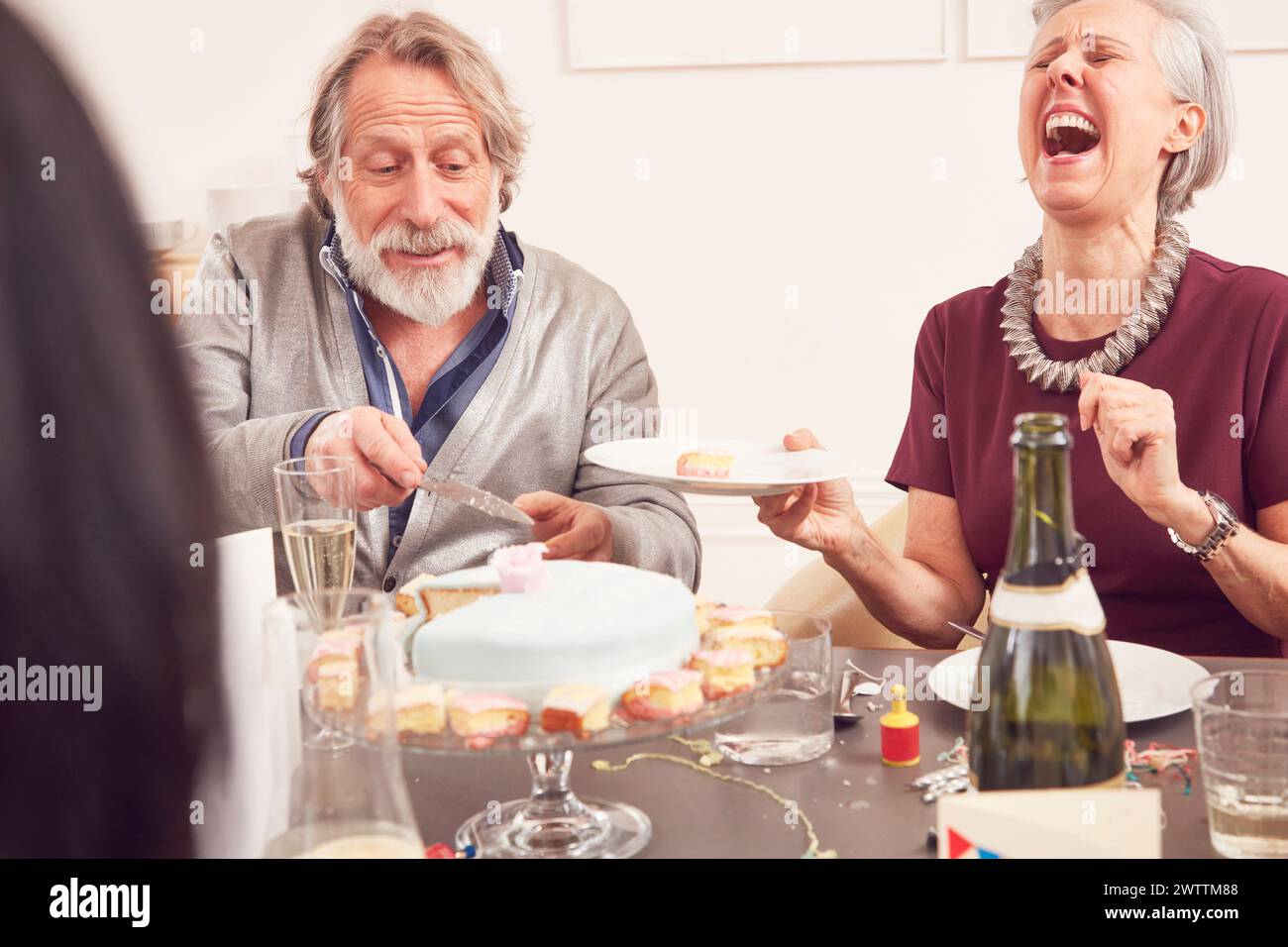 Una coppia anziana che ride ad una festa di compleanno. Foto Stock