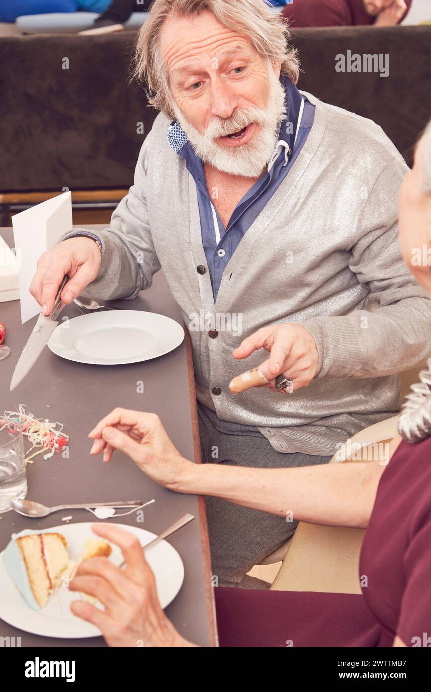 Uomo che fuma mentre cena con una donna Foto Stock