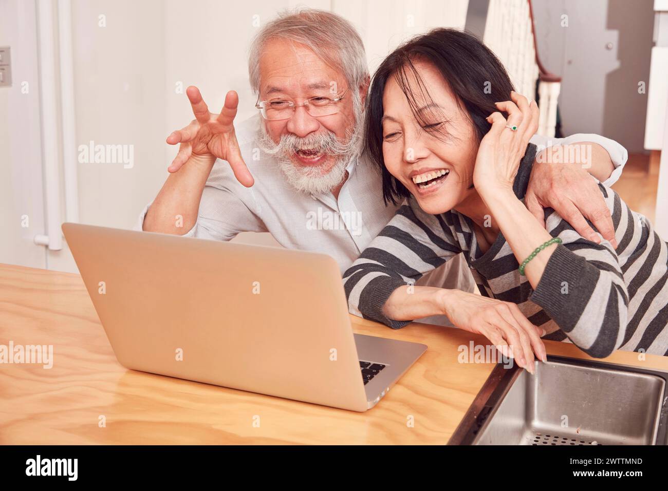 Due persone che ridono di fronte a un notebook Foto Stock