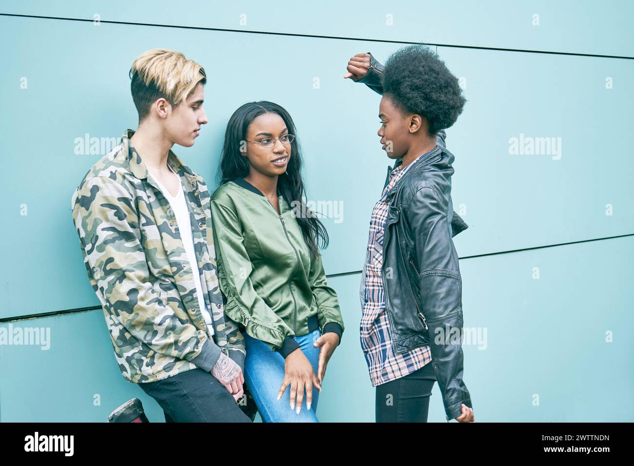 Tre persone in un contesto di verde scuro Foto Stock