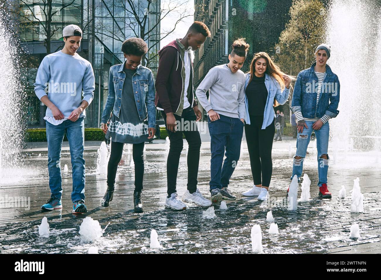 Gruppo di giovani adulti che camminano accanto a una fontana Foto Stock