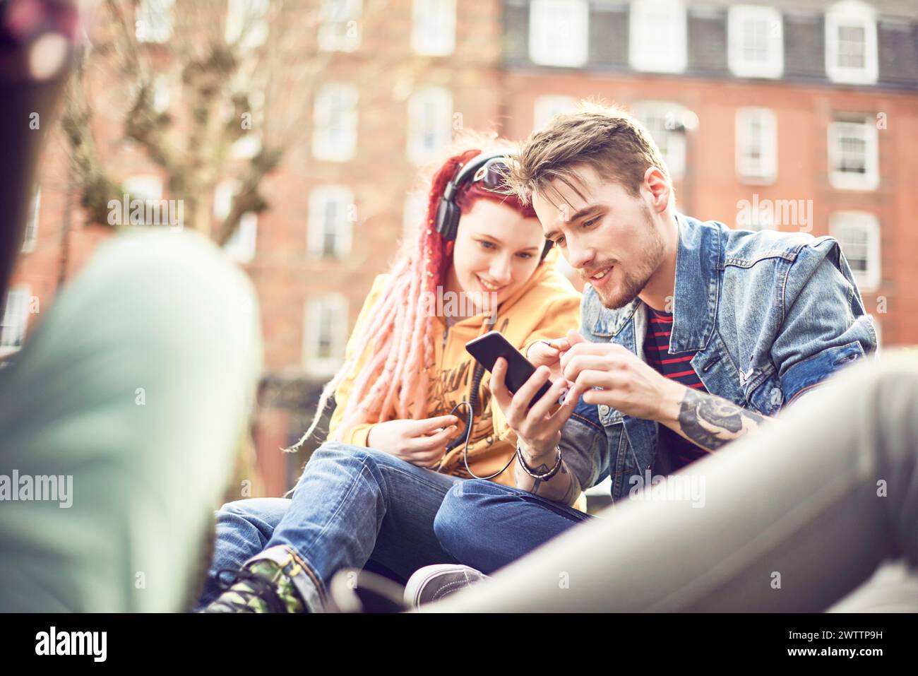 Due amici che condividono la musica su un telefono Foto Stock