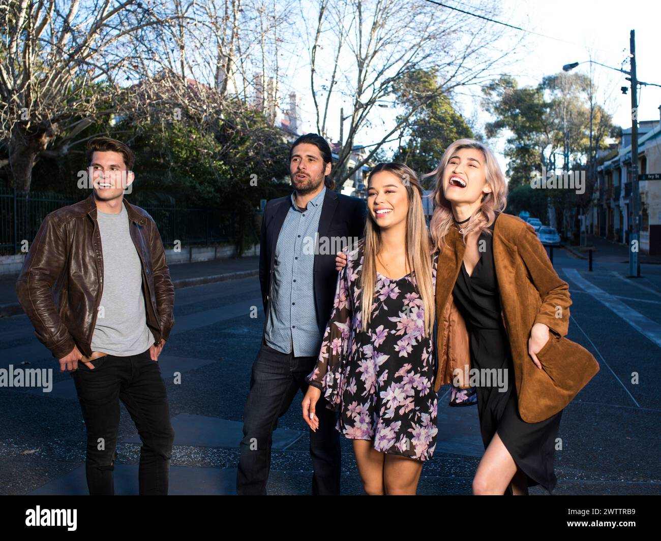 Quattro amici che ridono insieme in una strada di città Foto Stock