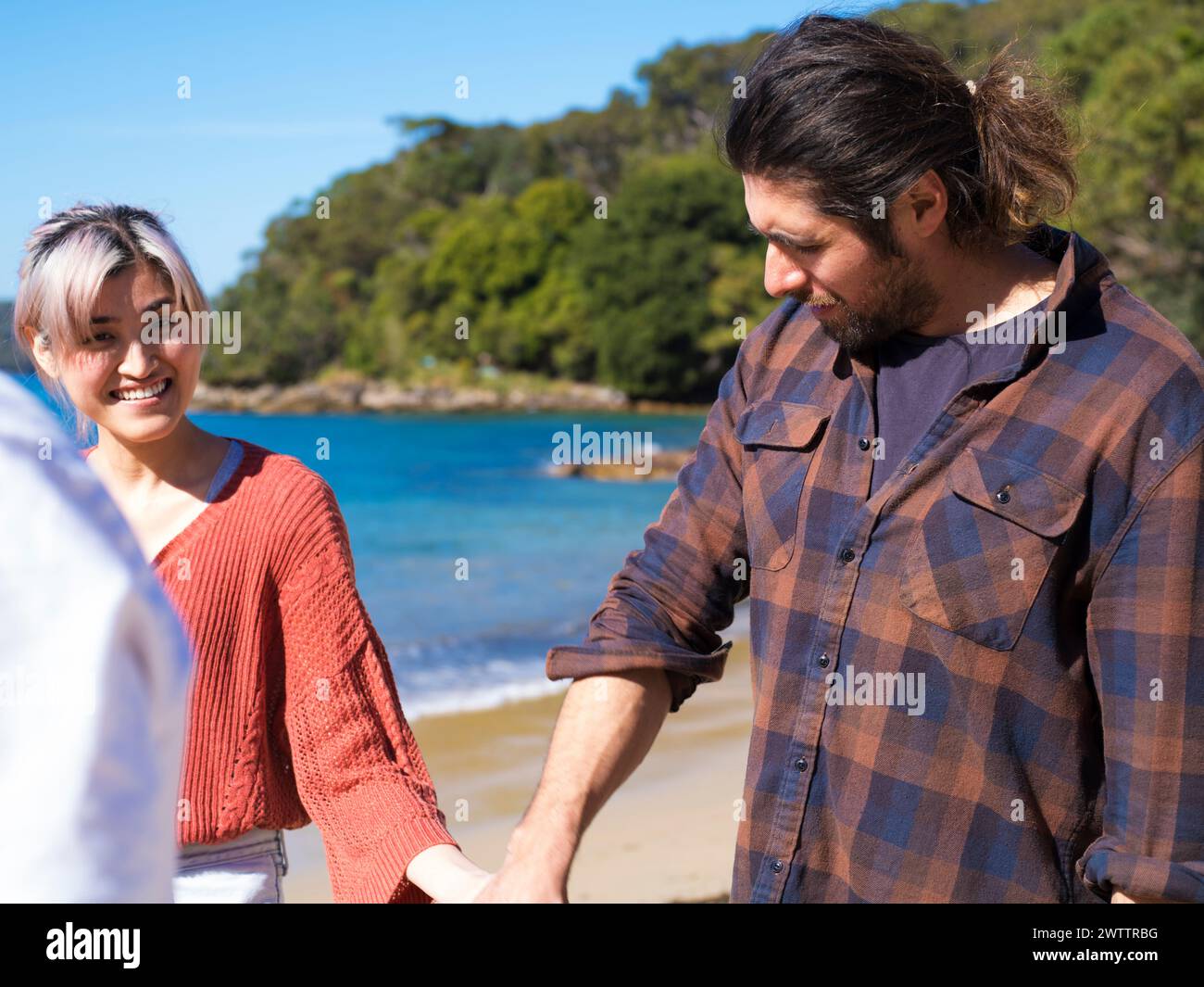 Due persone che stringono la mano vicino al mare Foto Stock