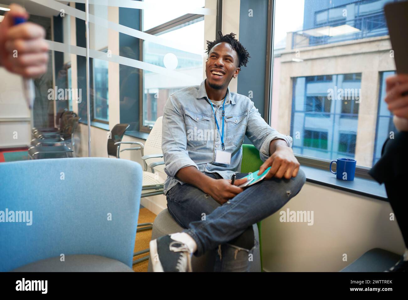 Uomo sorridente in un ambiente d'ufficio Foto Stock