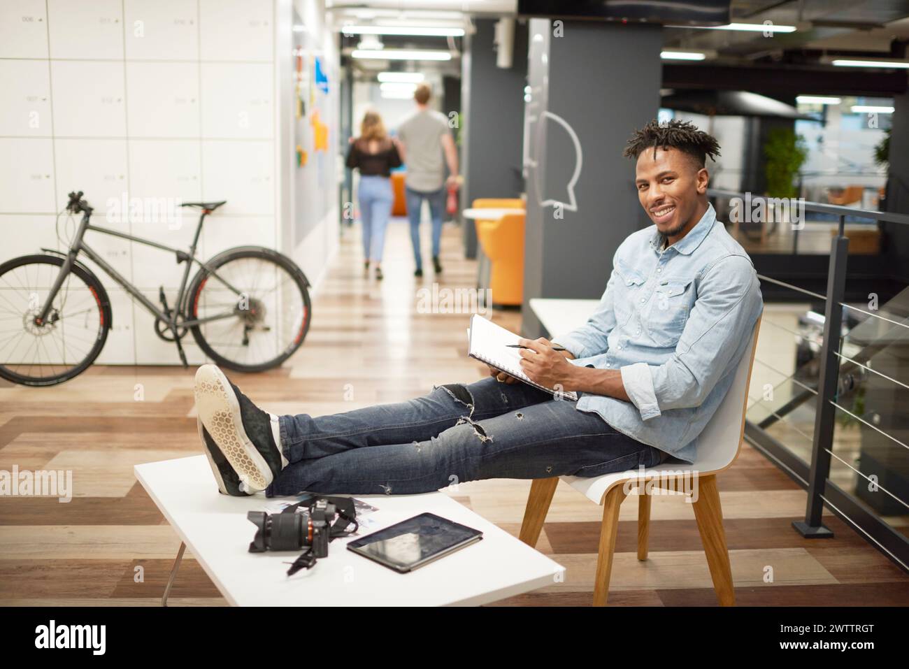 Uomo con notebook seduto in un ufficio moderno Foto Stock