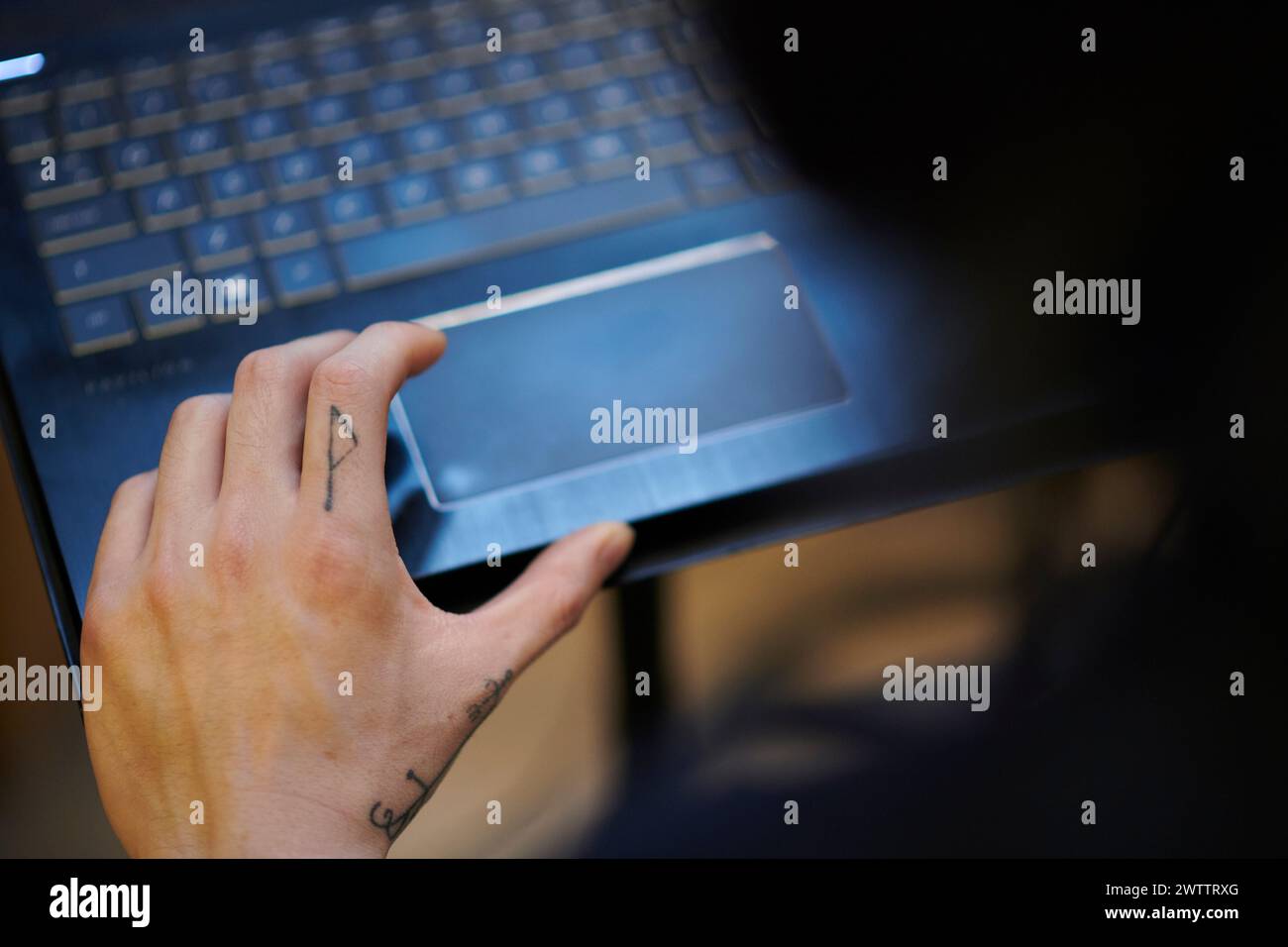 Primo piano di una mano sul trackpad di un laptop Foto Stock