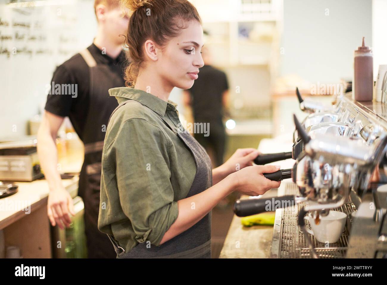 Barista che utilizza una macchina espresso Foto Stock