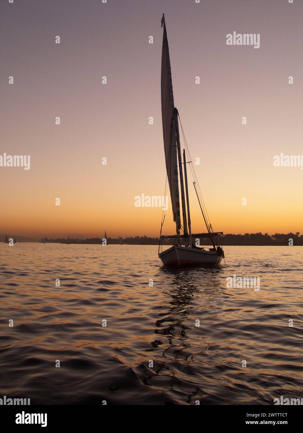 Barca a vela in acqua al tramonto Foto Stock