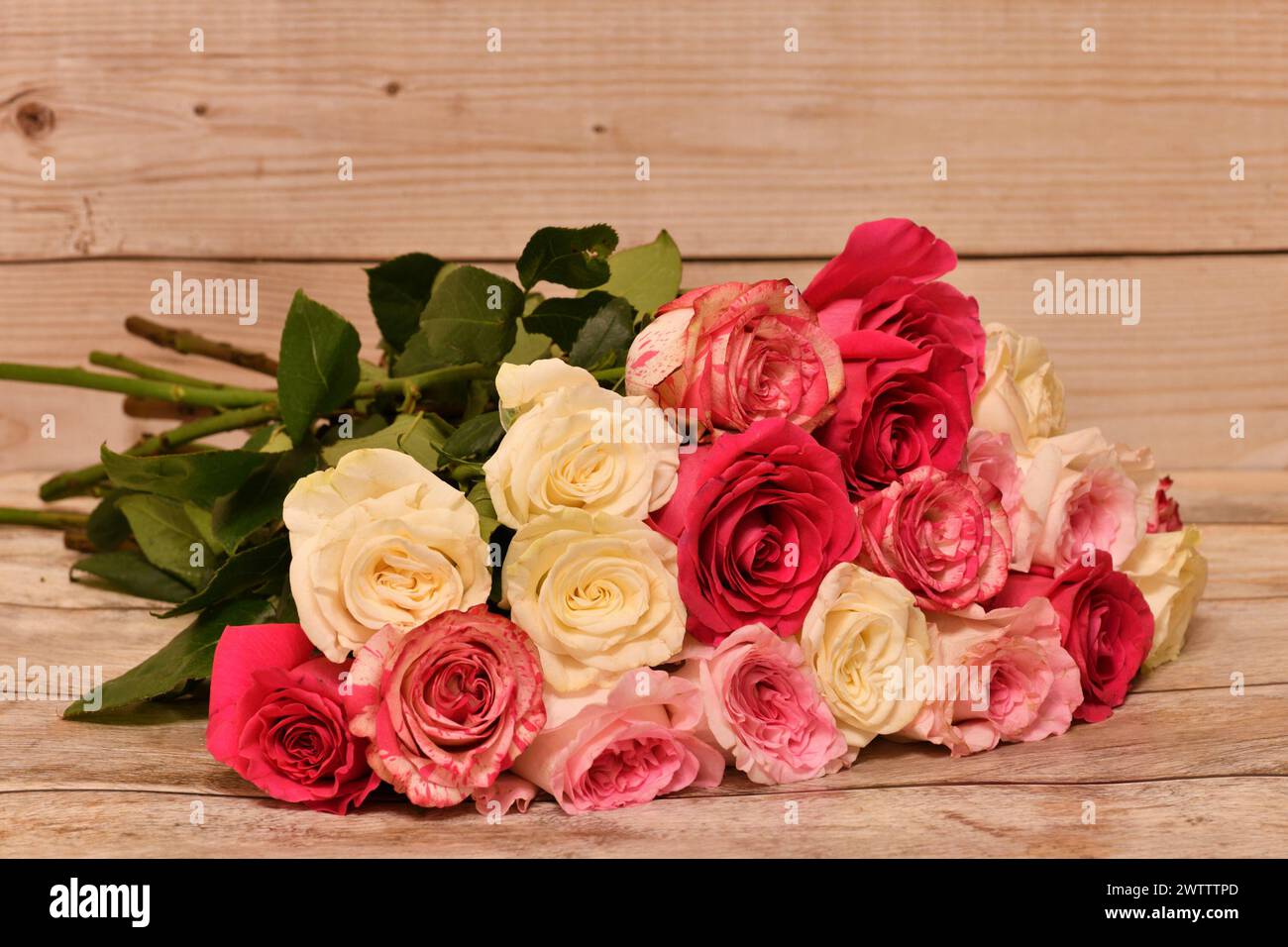 un bouquet di rose gialle e rosa giace sul tavolo Foto Stock