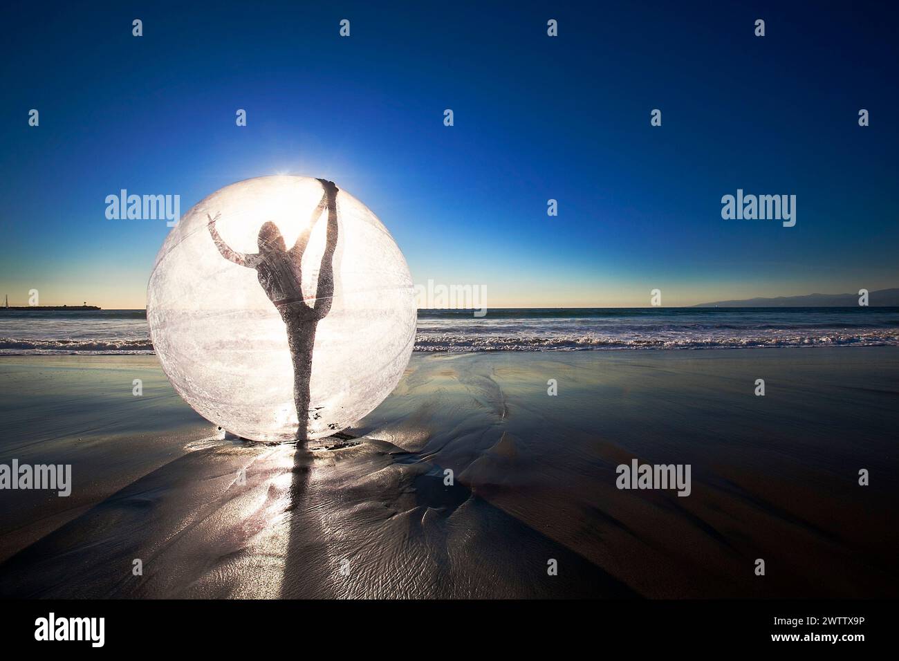 Silhouette in Orb on Beach al tramonto Foto Stock