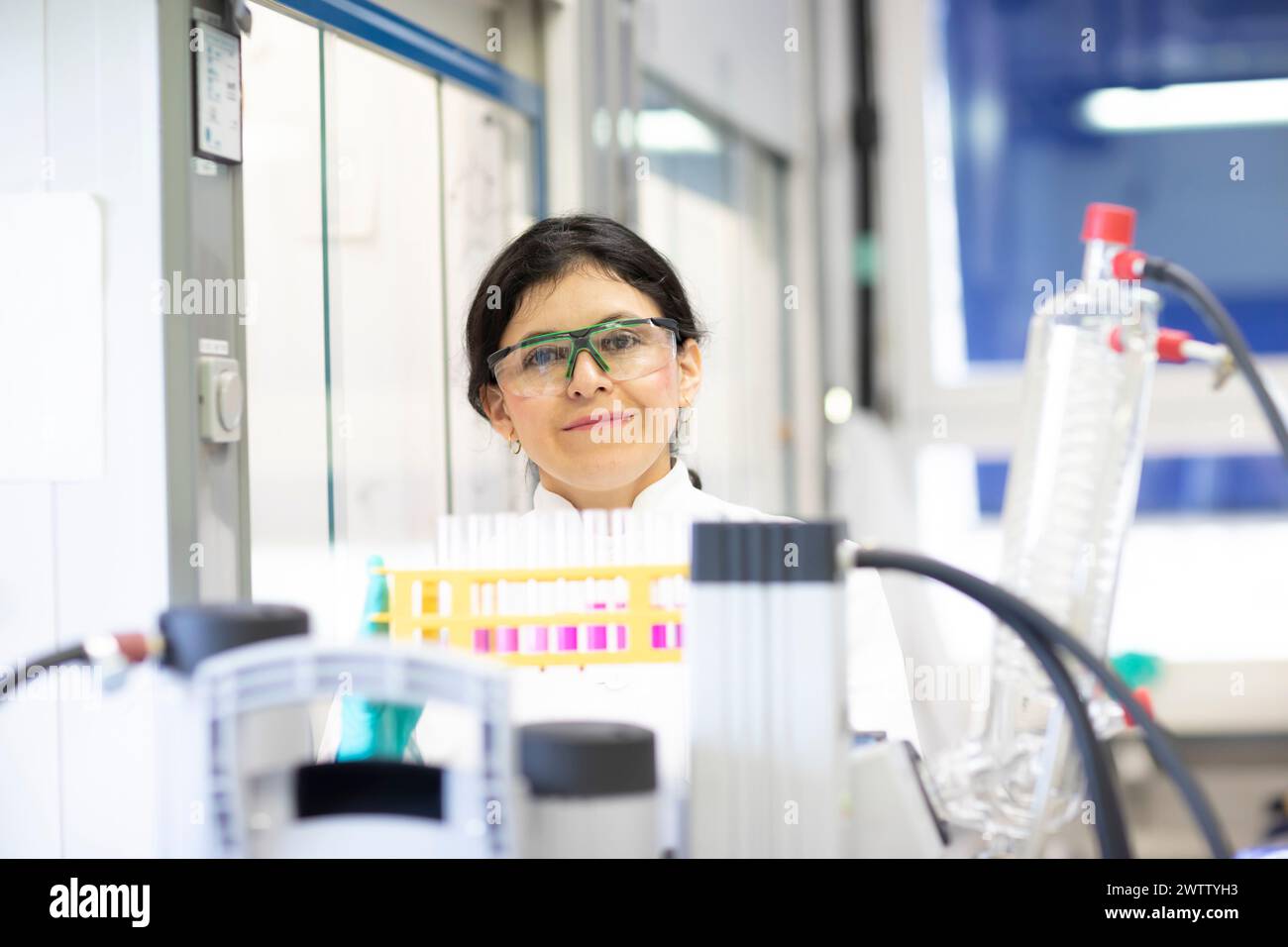 Scienziato sicuro con un sorriso brillante in un ambiente di laboratorio. Foto Stock
