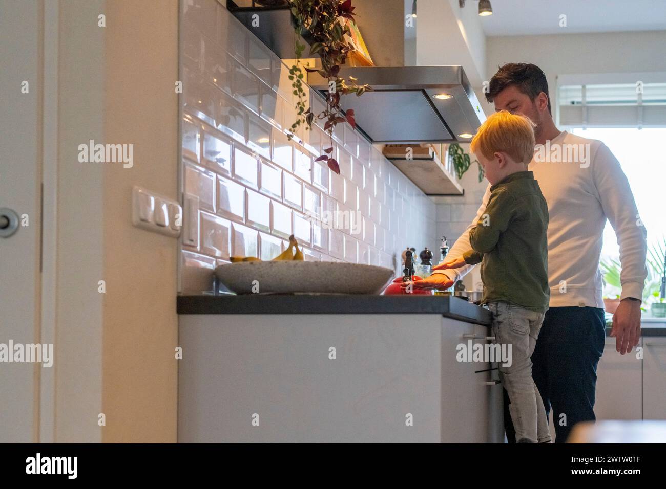 Un padre e un figlio che si legano alle attività di cucina. Foto Stock