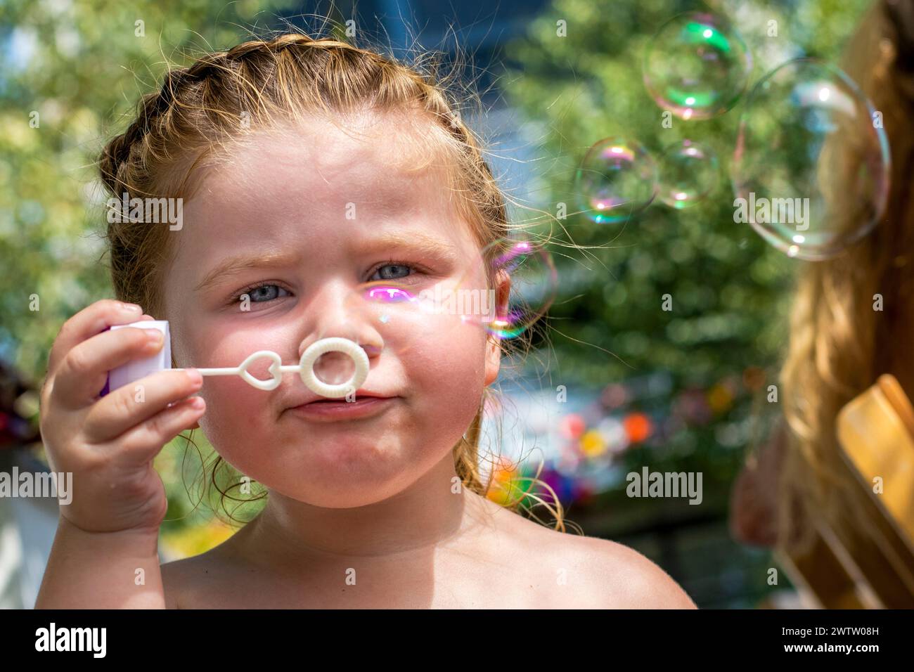 Bambino che soffia bolle in una giornata di sole Foto Stock