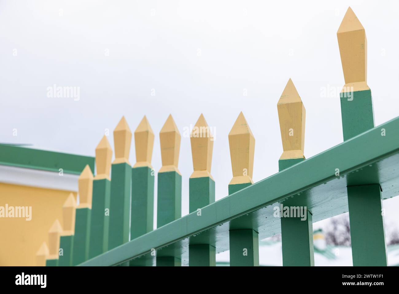 Recinzione in legno vintage con barre nitide gialle verdi, foto ravvicinata con messa a fuoco morbida selettiva Foto Stock