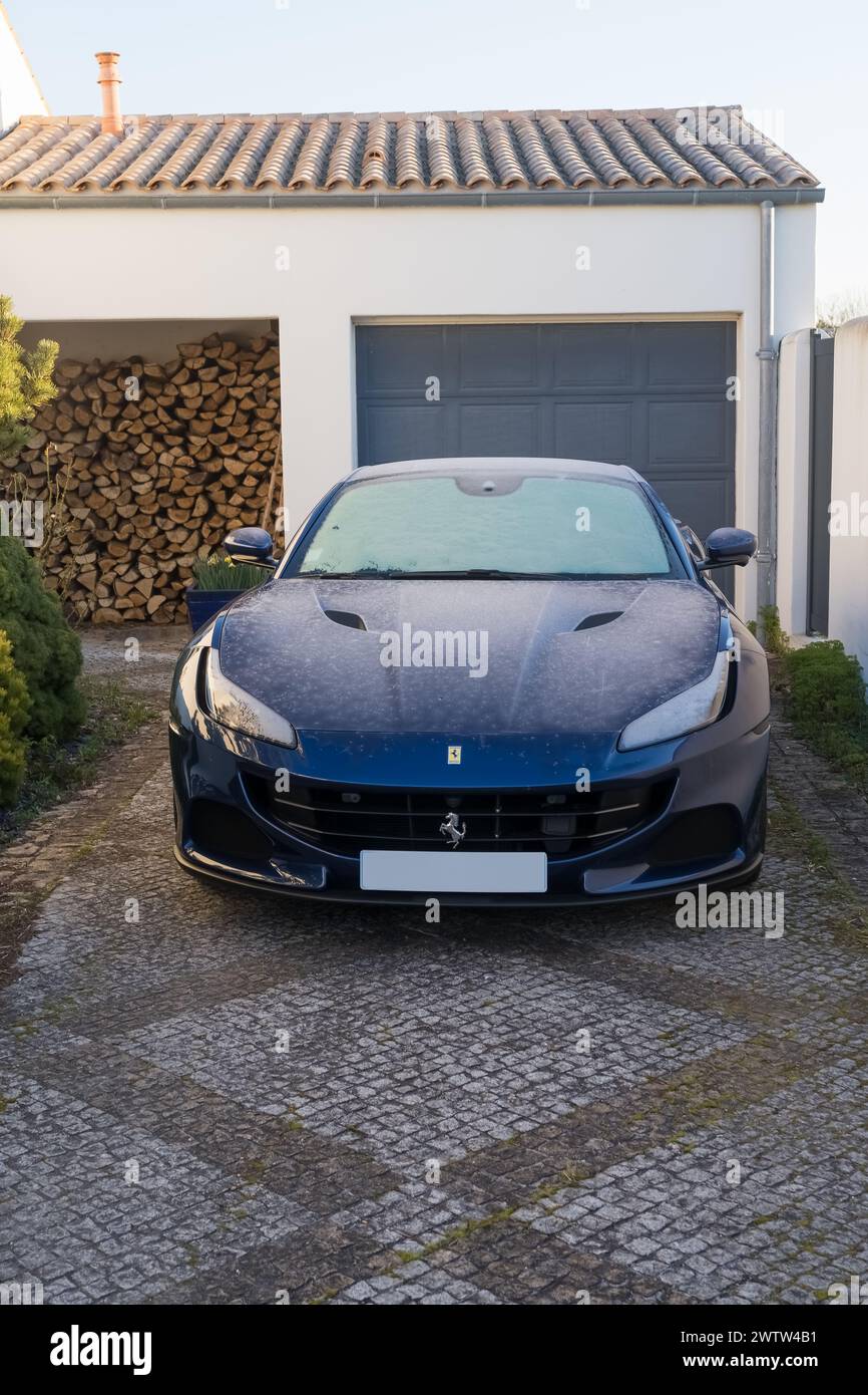 Bordeaux, 28 febbraio 2023. Una Ferrari blu parcheggiata di fronte a un garage in una giornata ghiacciata. Sul cofano sono visibili tracce di ghiaccio. Foto Stock