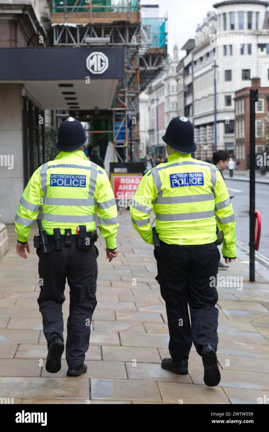 Agenti di polizia metropolitana che camminano per le strade di Londra Foto Stock