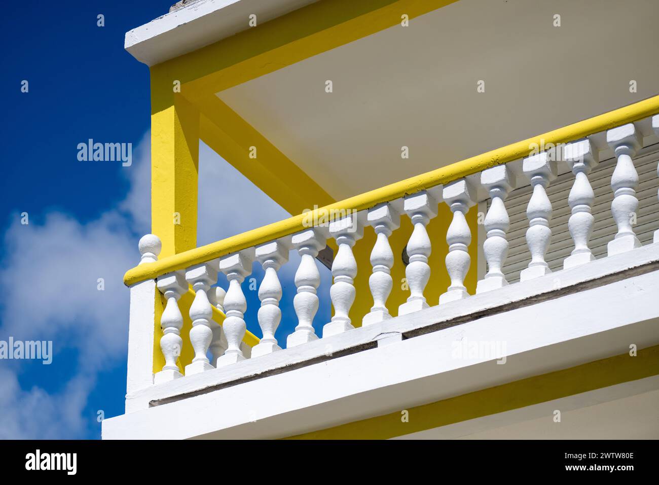 L'immagine vivida di un edificio giallo e bianco contrasta con un cielo blu luminoso che mostra la simmetria architettonica Foto Stock