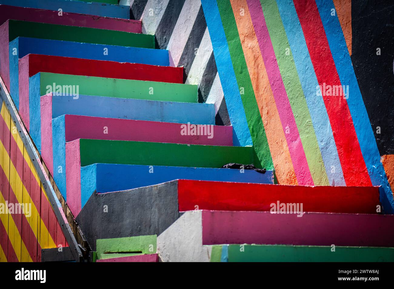 La prospettiva ad alto angolo di una scala all'aperto con strisce in più colori che creano un'immagine sorprendente Foto Stock